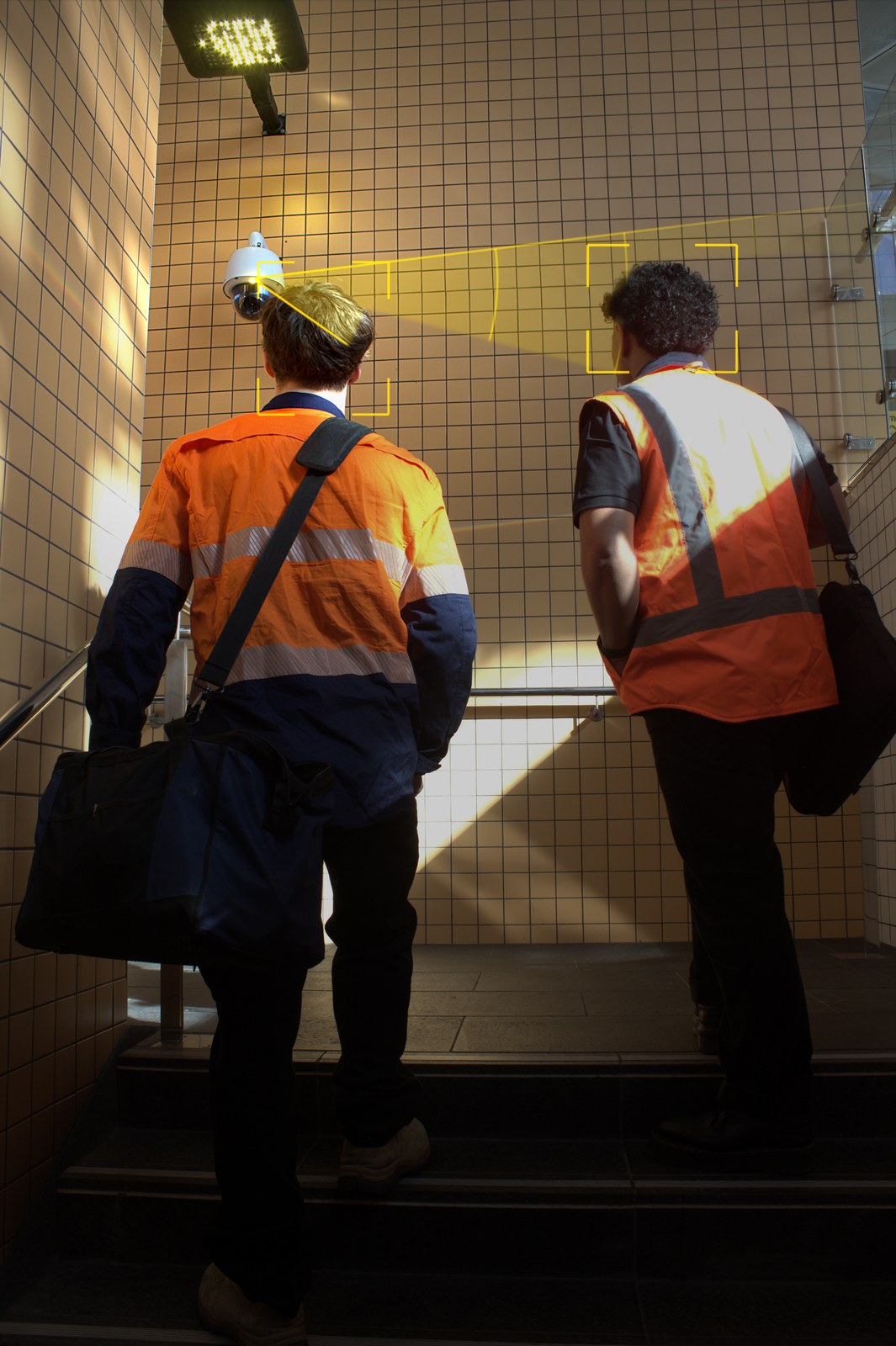 Dome CCTV camera tracking two people on a tiled staircase with on-screen bounding boxes