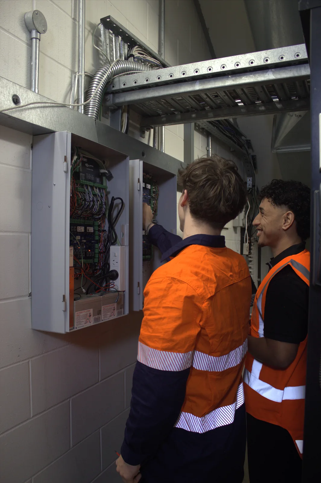 Technicians working together on site control panels